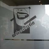 plaatsing belettering logo en glasfolie voor orthodont tandarts op glas